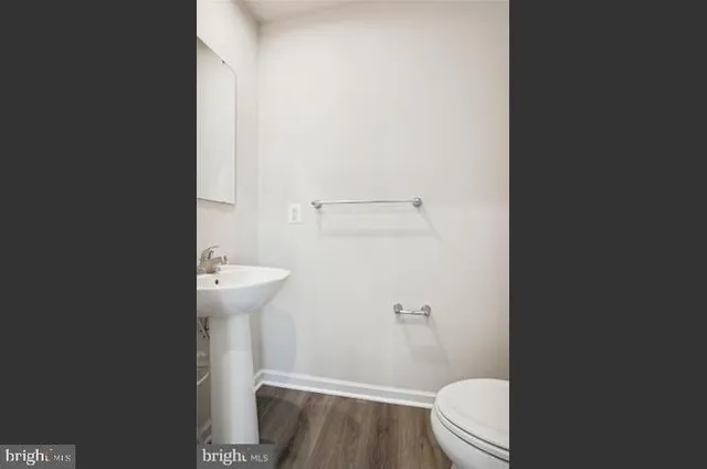 a bathroom with a granite countertop toilet and a sink