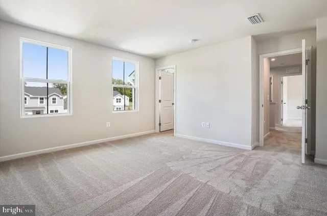 an empty room with windows and closet