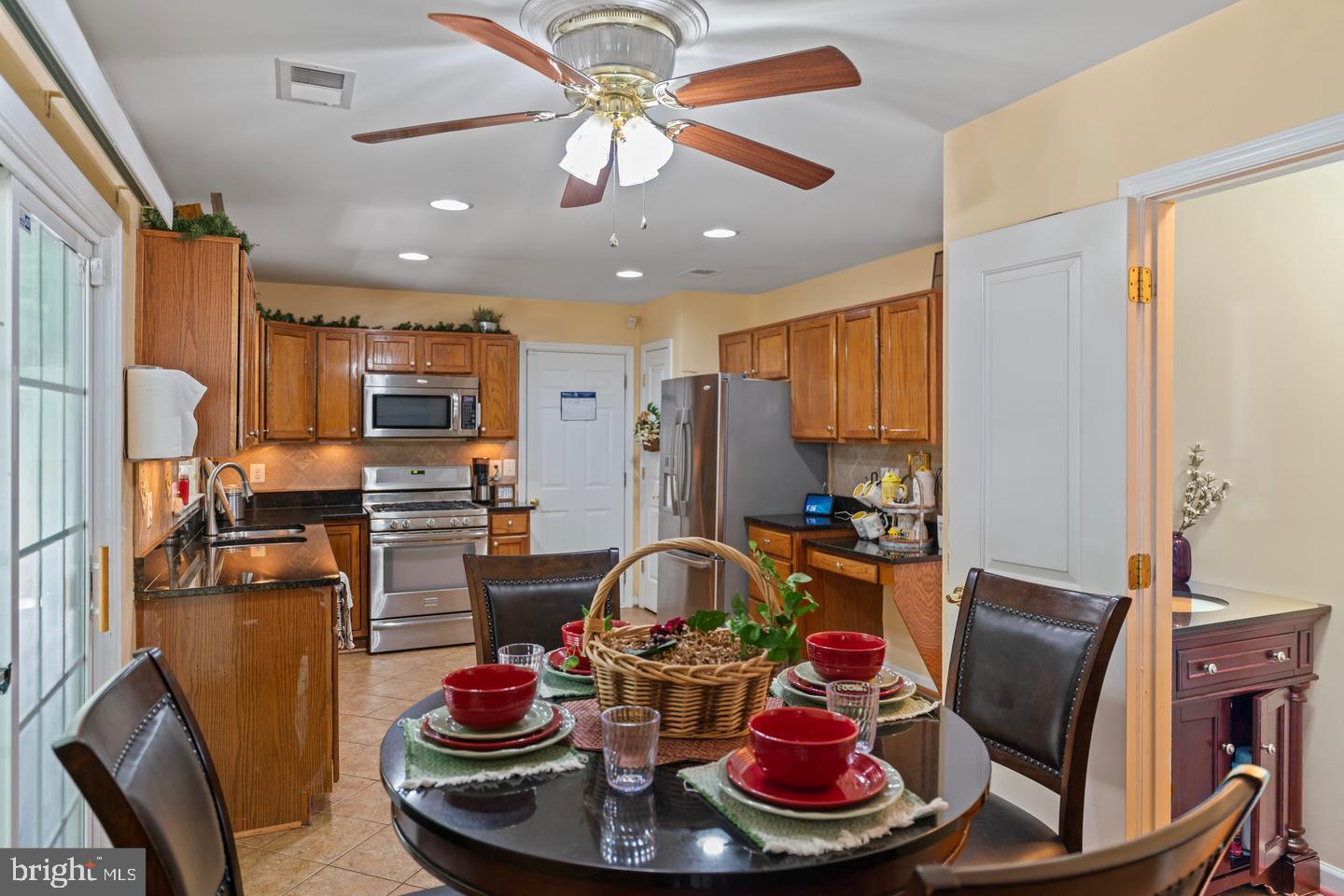 a room with stainless steel appliances furniture a chandelier and a view of kitchen