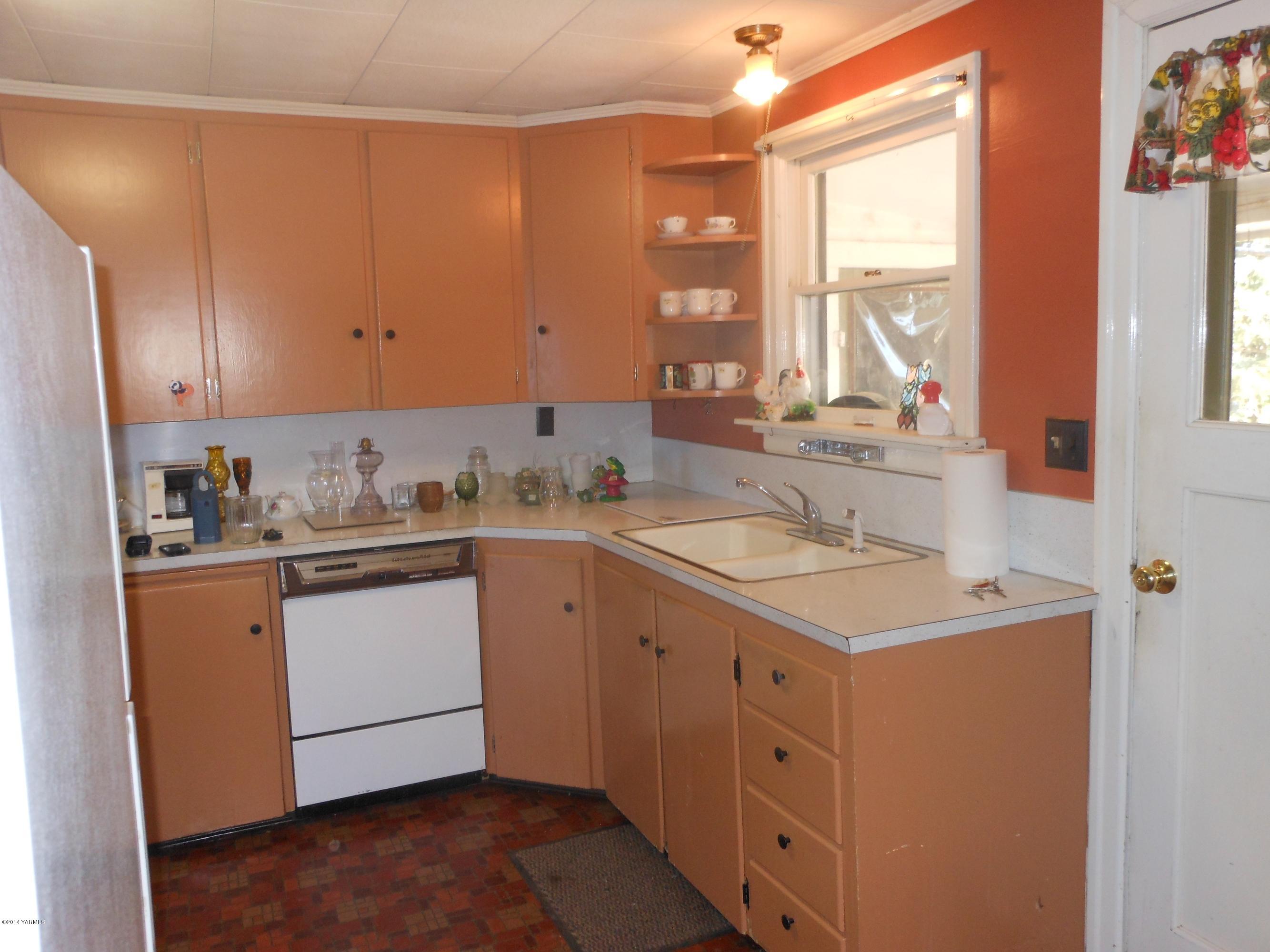 2921 Harrah Road Wapato, WA 98951 - Photo 4 of 29 a kitchen with sink cabinets and window