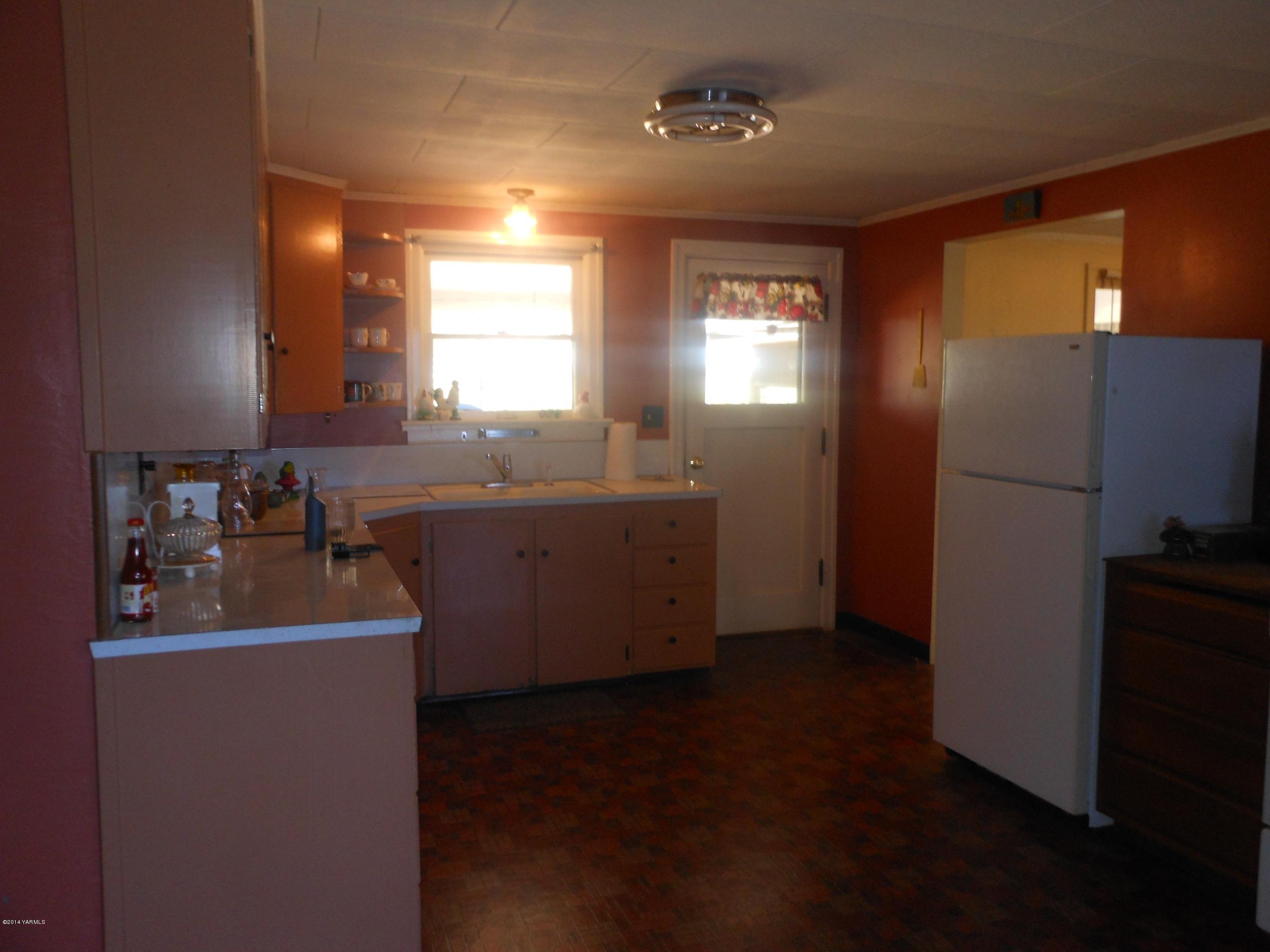 2921 Harrah Road Wapato, WA 98951 - Photo 7 of 29 a kitchen with sink refrigerator and window