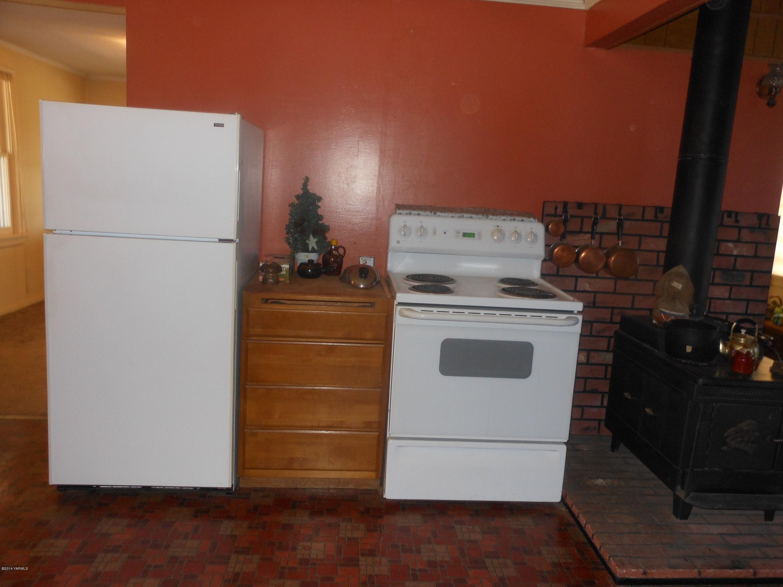 2921 Harrah Road Wapato, WA 98951 - Photo 8 of 29 a white refrigerator freezer and a stove sitting inside of a kitchen