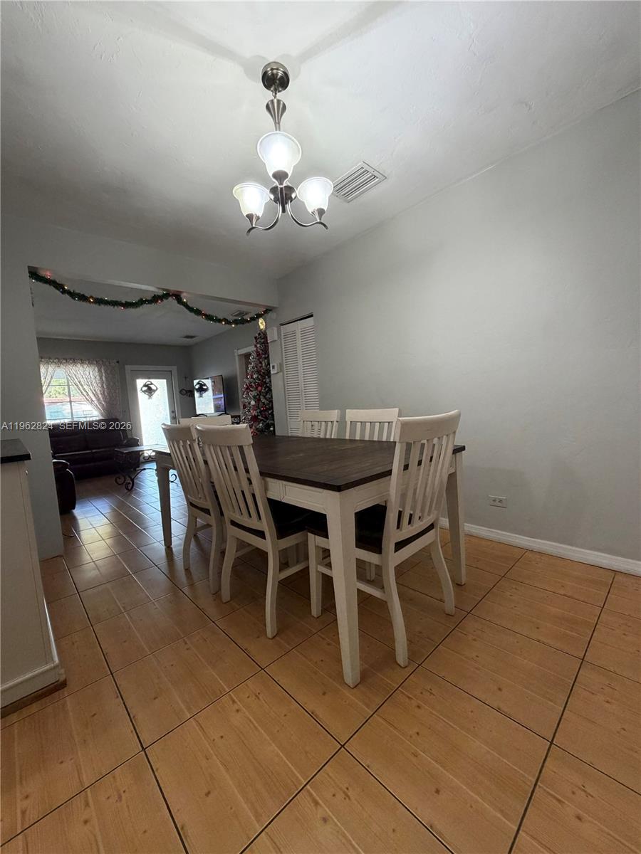 2460 Northwest 33rd Street Miami, FL 33142 - Photo 11 of 33 a view of a dining room with furniture and chandelier