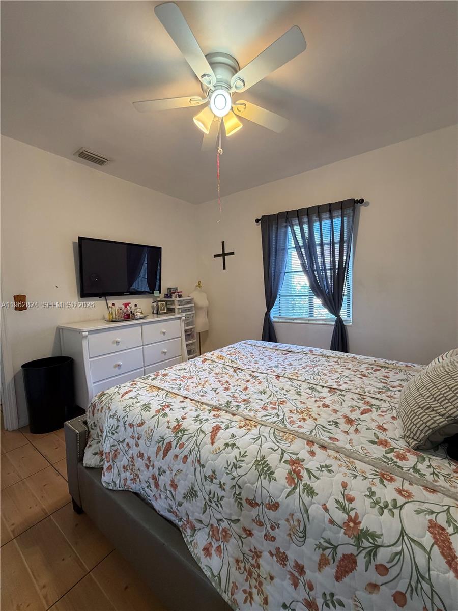 2460 Northwest 33rd Street Miami, FL 33142 - Photo 21 of 33 a bedroom with a bed and a flat screen tv