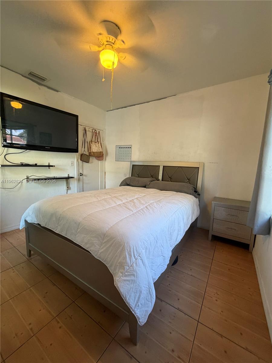 2460 Northwest 33rd Street Miami, FL 33142 - Photo 26 of 33 a bedroom with a bed and flat screen tv