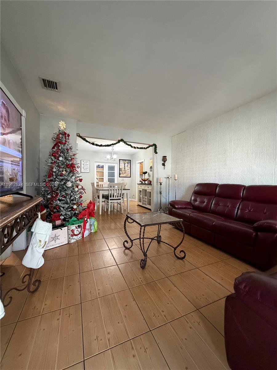 2460 Northwest 33rd Street Miami, FL 33142 - Photo 7 of 33 a living room with furniture and a potted plant
