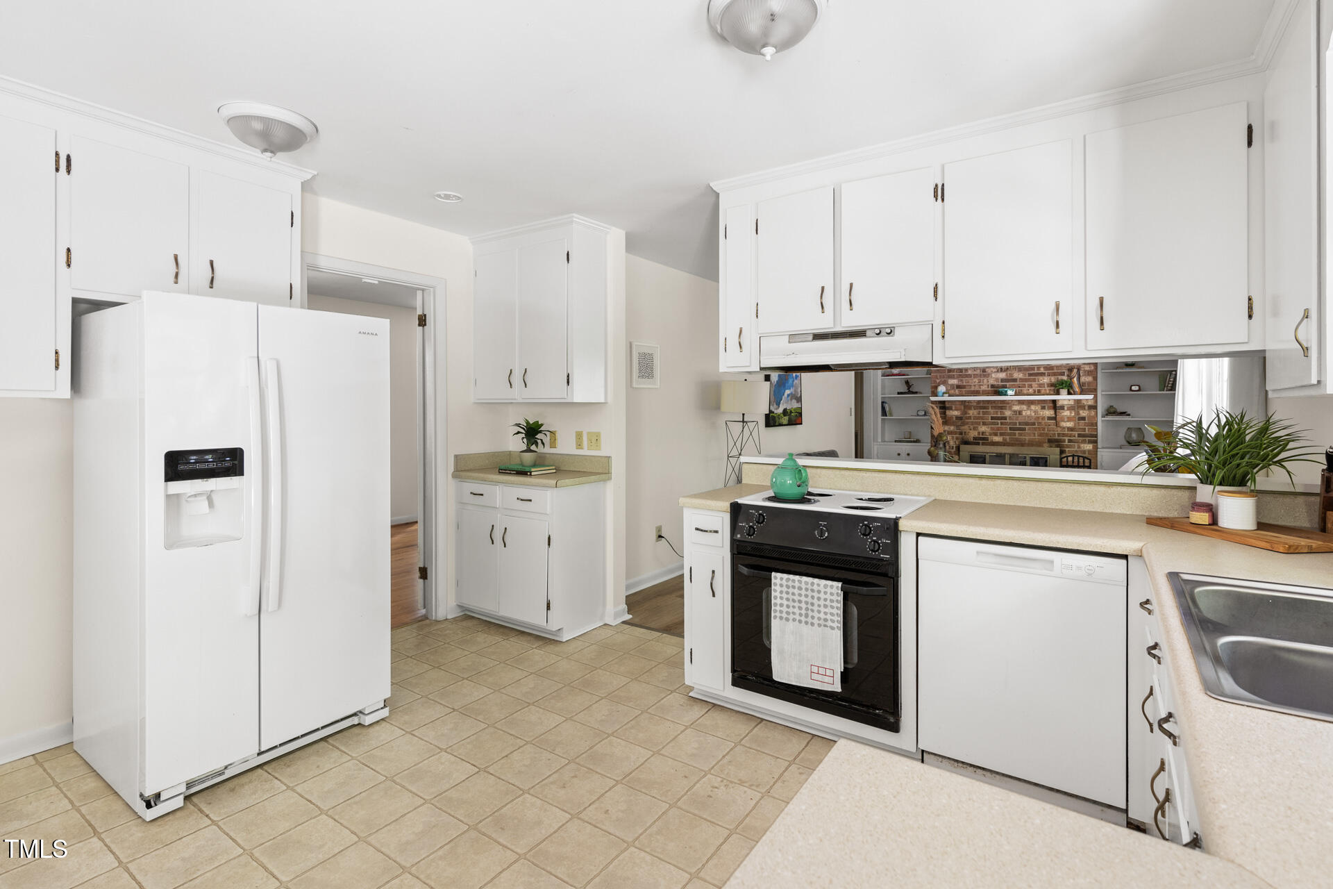 324 Woodhaven Road Chapel Hill, NC 27514 - Photo 12 of 32 a kitchen with white cabinets and white appliances
