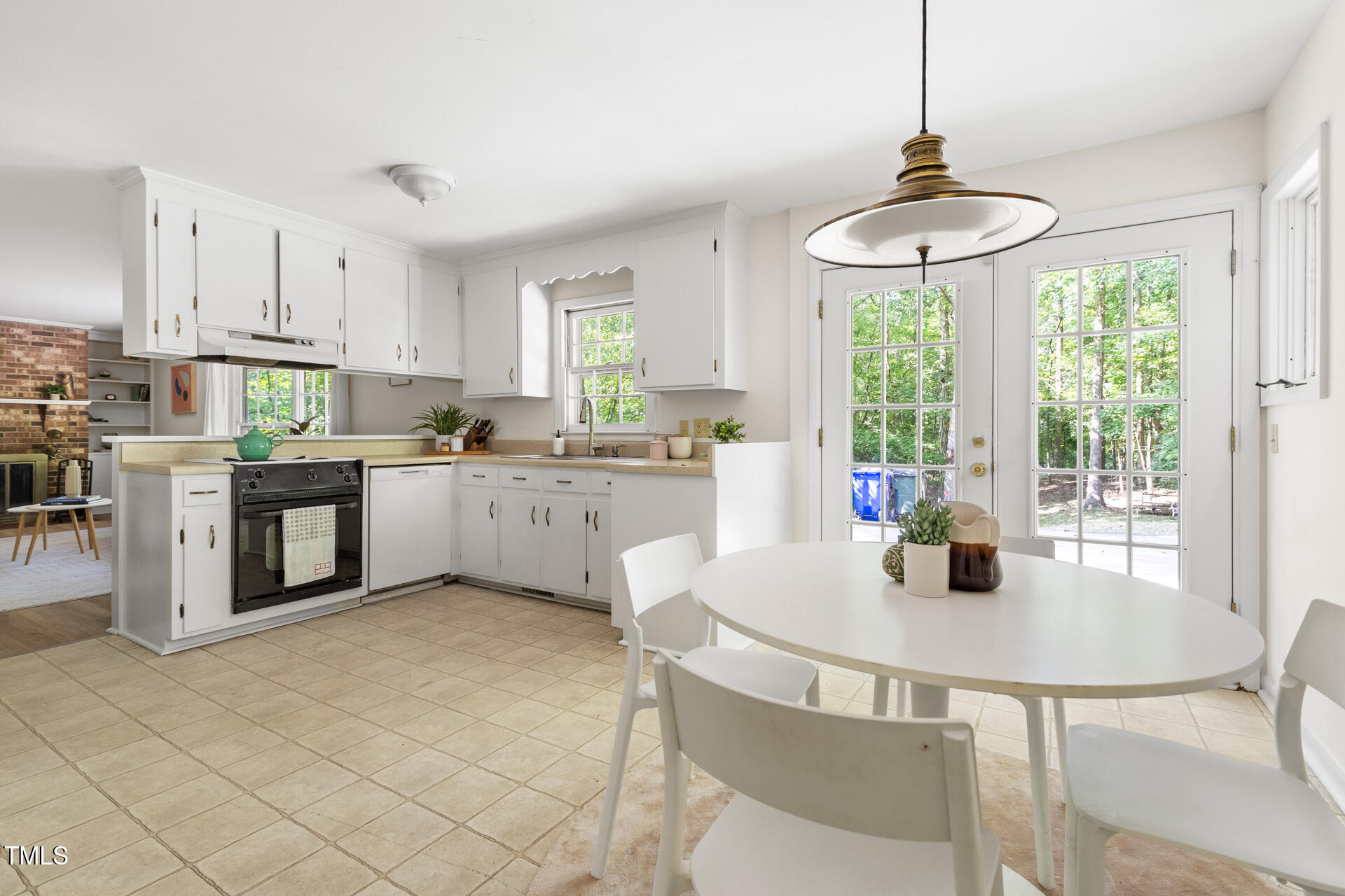 324 Woodhaven Road Chapel Hill, NC 27514 - Photo 14 of 32 a kitchen with stainless steel appliances granite countertop a sink a stove a kitchen island with a dining table and chairs