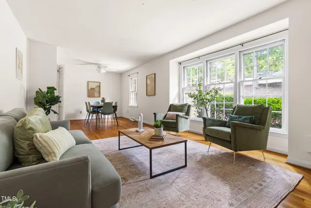 a living room with furniture kitchen view and large windows