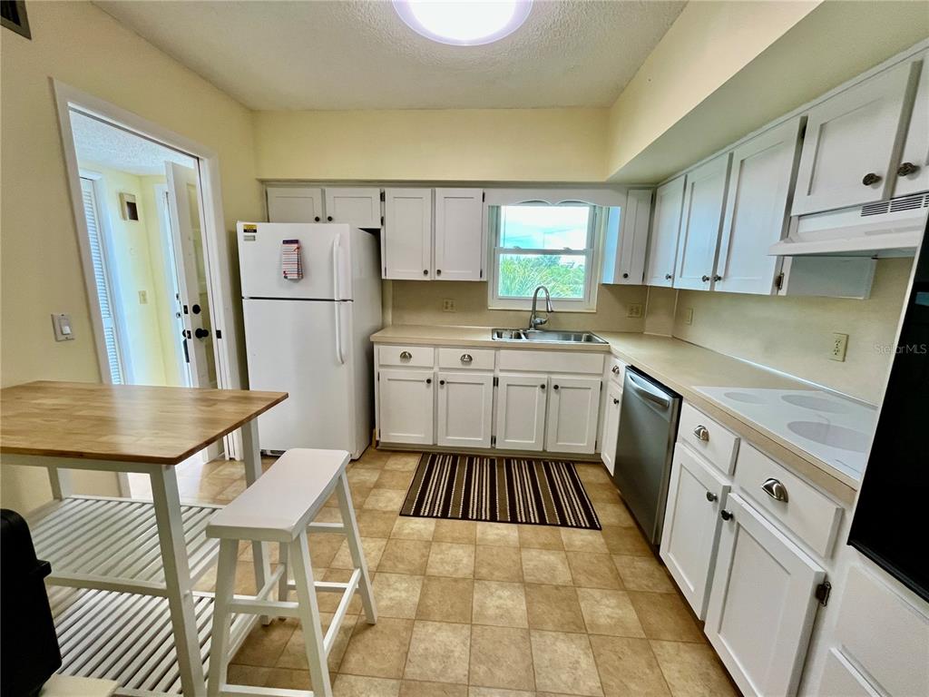 2292 Costa Rican Drive, Unit 22 Clearwater, FL 33763 - Photo 9 of 44 a kitchen with a sink a stove a refrigerator and cabinets