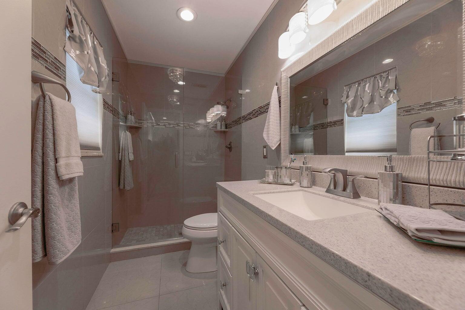2935 Lake Worth Road Palm Springs, FL 33461 - Photo 15 of 22 a bathroom with a double vanity sink toilet and shower