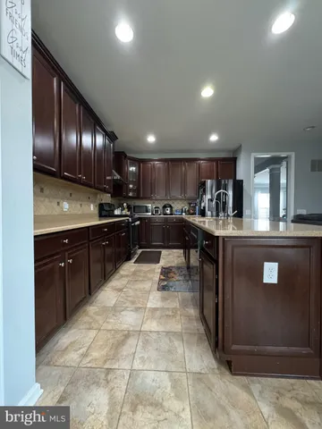 a kitchen with a sink a counter top space stainless steel appliances and cabinets