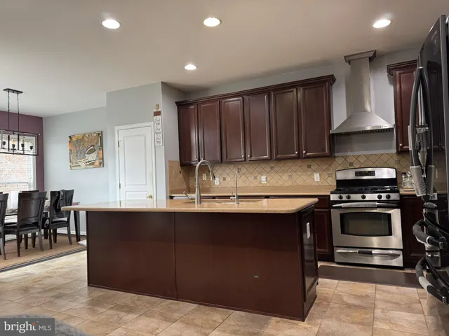 a kitchen with kitchen island granite countertop a sink counter top space appliances and cabinets