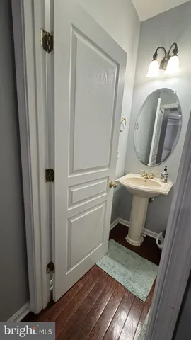 a view of a hallway with wooden floor windows and a bathroom