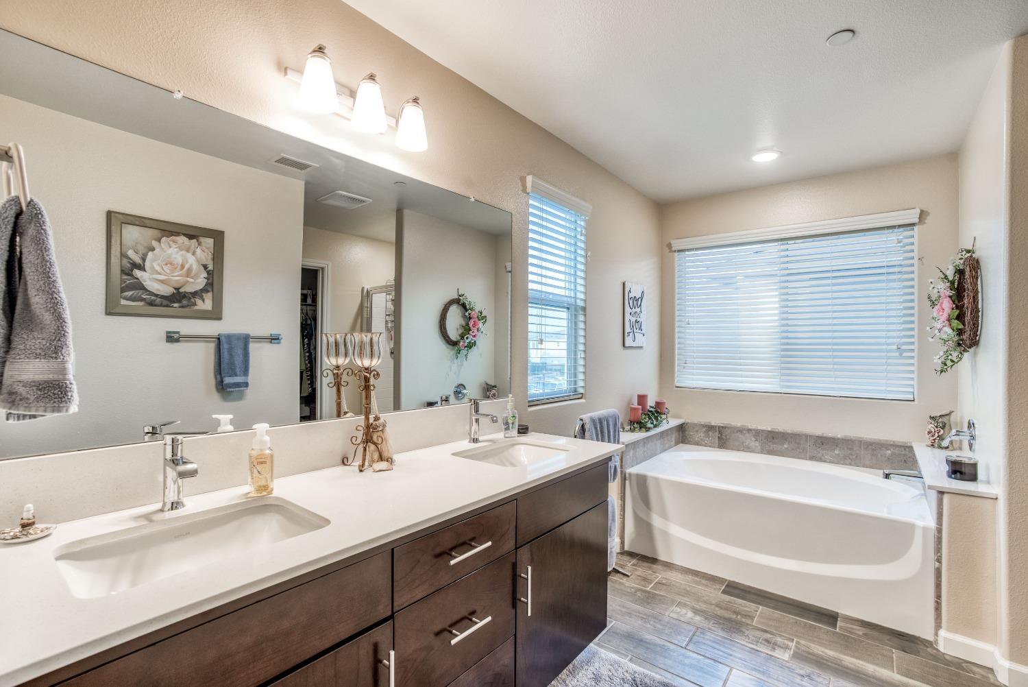 3678 Parkstone Way Clovis, CA 93619 - Photo 13 of 34 a bathroom with a bathtub double vanity sink and a mirror