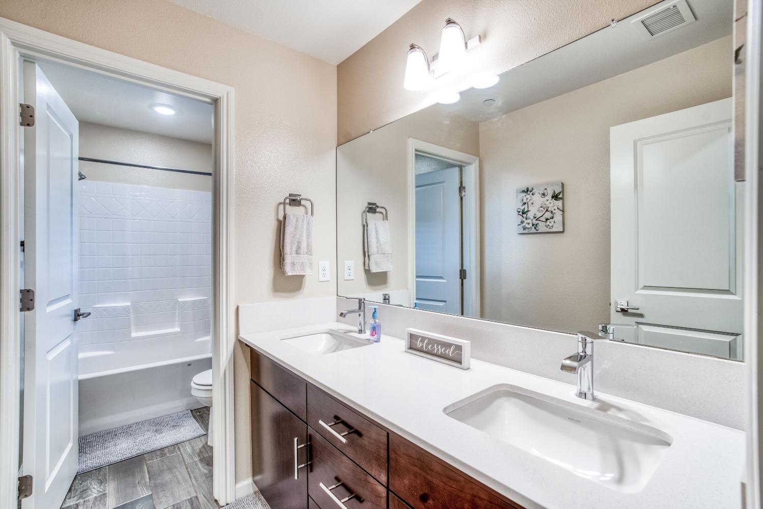 3678 Parkstone Way Clovis, CA 93619 - Photo 16 of 34 a bathroom with a double vanity sink mirror and bathtub