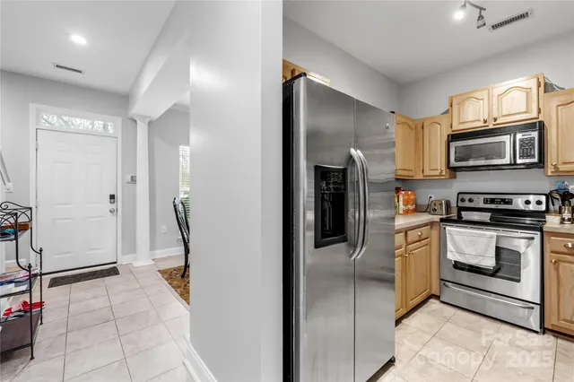 a kitchen with granite countertop a refrigerator and a stove top oven