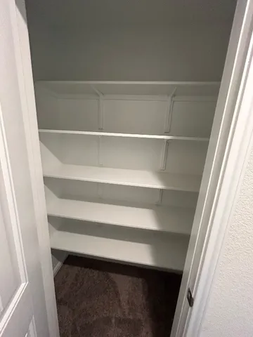a view of walk in closet with empty racks