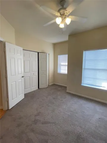 a view of empty room with window and ceiling fan
