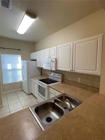 a kitchen that has a sink and a stove in it