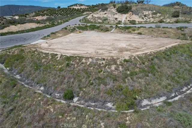 a view of a dry yard with wooden fence