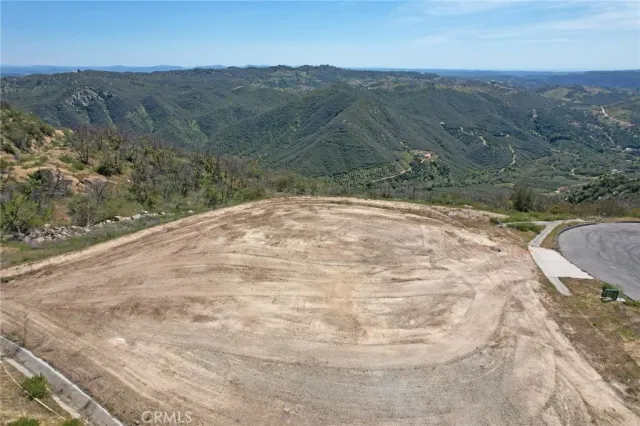 a view of a dry yard with mountains in the background