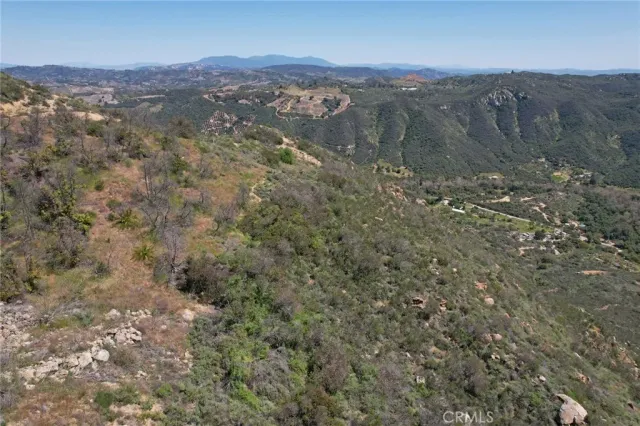 a view of a dry field with mountains in the background