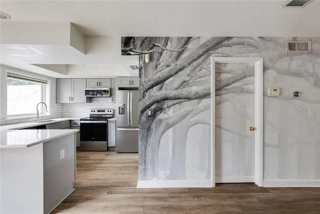 a view of a kitchen with a sink wooden floor and cabinets