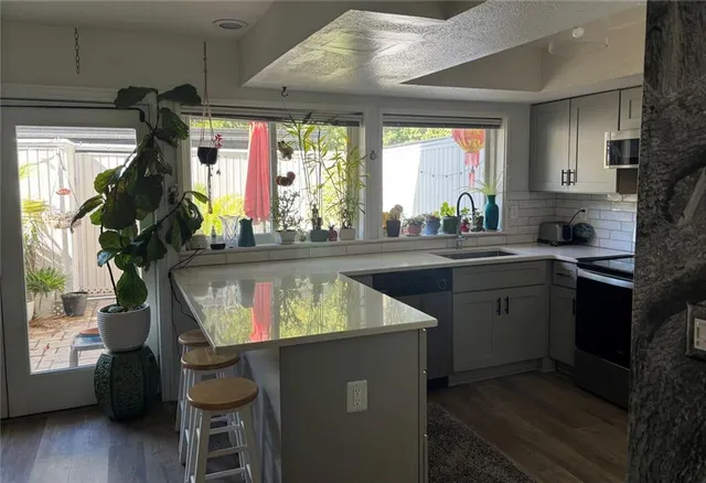 a view of a kitchen with wooden floor and electronic appliances