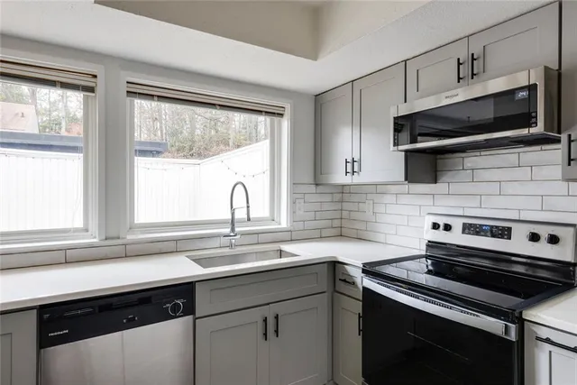 a kitchen with a refrigerator sink and cabinets