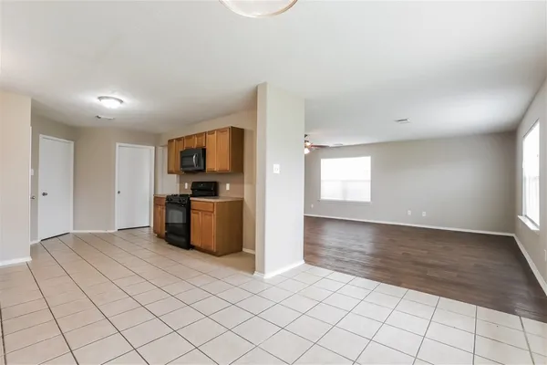 a kitchen with granite countertop a refrigerator and a stove top oven
