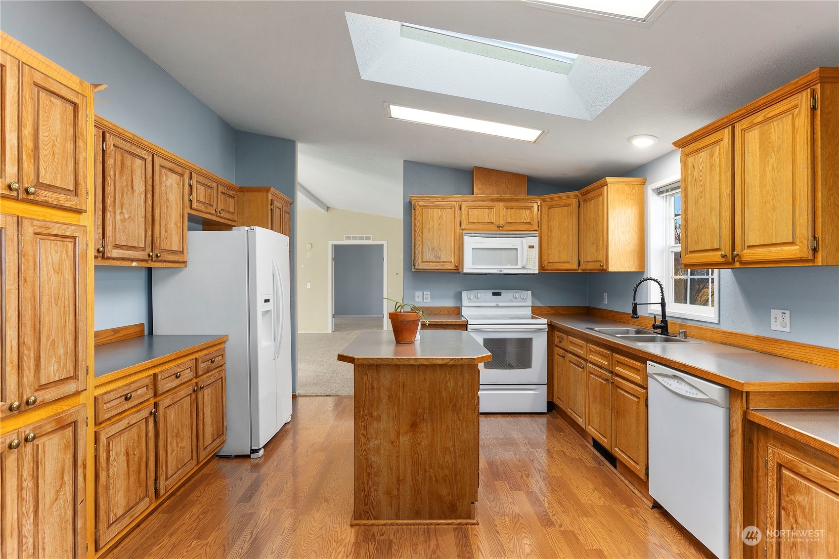 208 Carlsborg Road Sequim, WA 98382 - Photo 13 of 40 a kitchen with stainless steel appliances granite countertop a refrigerator a sink dishwasher a stove and white countertops with wooden floor