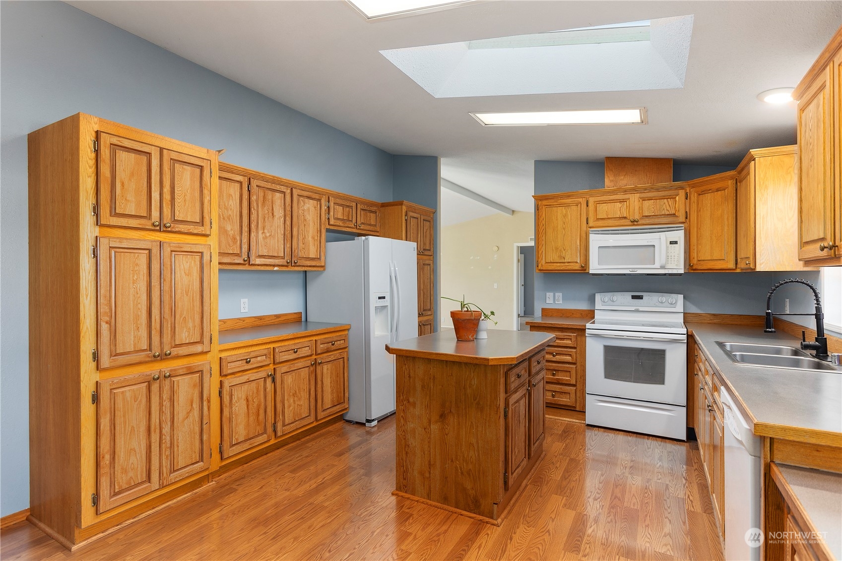 208 Carlsborg Road Sequim, WA 98382 - Photo 14 of 40 a kitchen with stainless steel appliances granite countertop a refrigerator a sink dishwasher and wooden cabinets with wooden floor