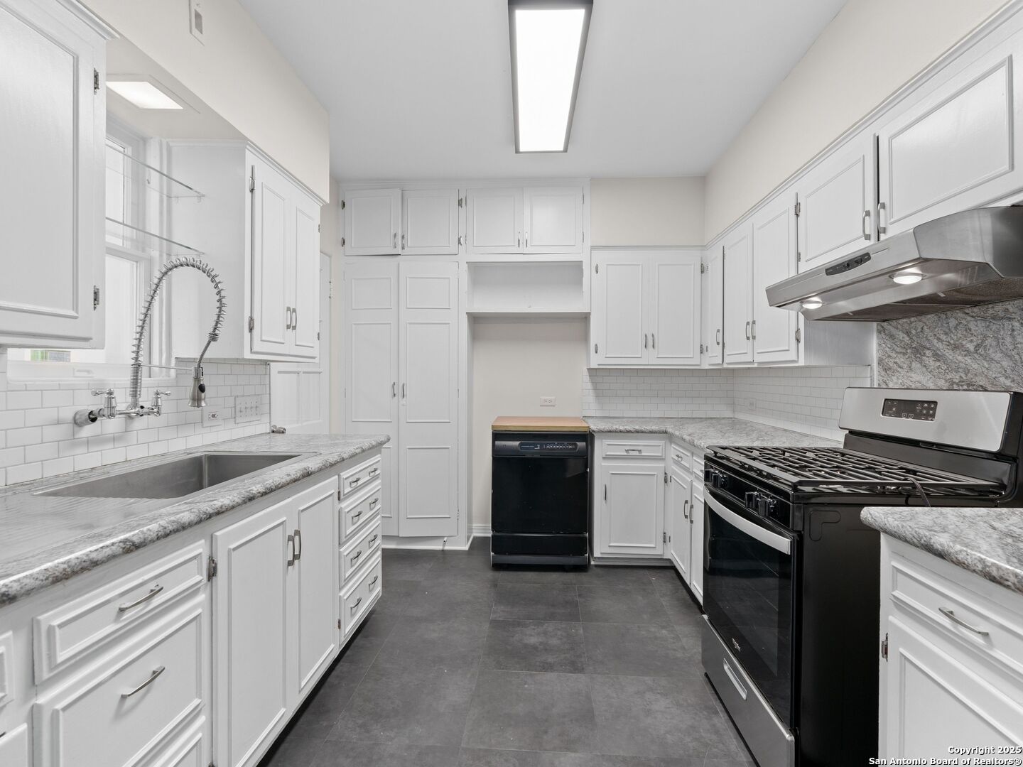 146 Terrell Road Alamo Heights, TX 78209 - Photo 14 of 29 a kitchen with stainless steel appliances granite countertop a stove sink and cabinets