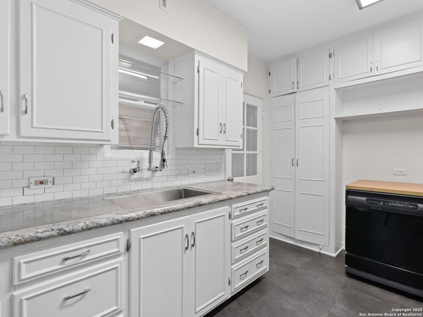 146 Terrell Road Alamo Heights, TX 78209 - Photo 15 of 29 a kitchen with granite countertop white cabinets and a sink