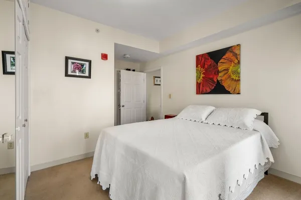 a bedroom with a bed and painting on the wall