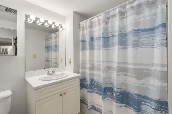 a bathroom with a sink vanity mirror and toilet