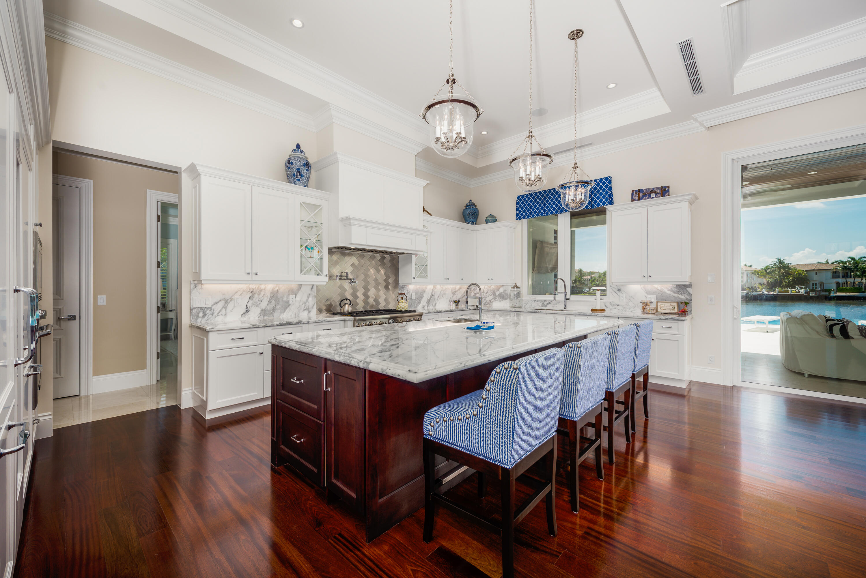 976 Cypress Drive Delray Beach, FL 33483 - Photo 12 of 38 a kitchen with granite countertop a stove a sink dishwasher a dining table and chairs with wooden floor