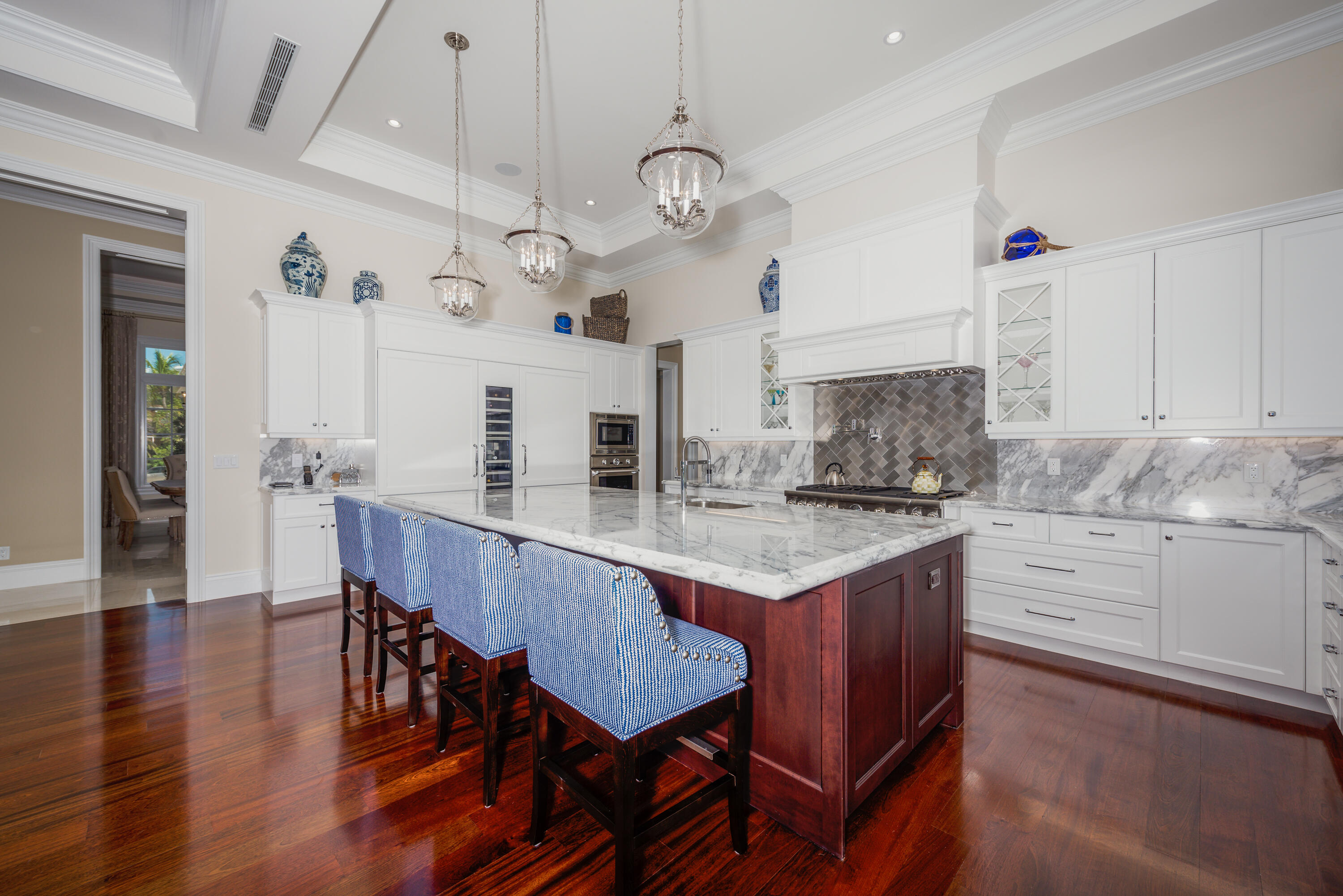 976 Cypress Drive Delray Beach, FL 33483 - Photo 10 of 38 a kitchen with a dining table chairs sink and cabinets