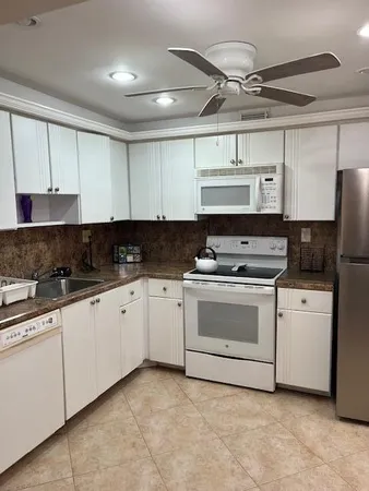 a kitchen with stainless steel appliances granite countertop a stove and white cabinets