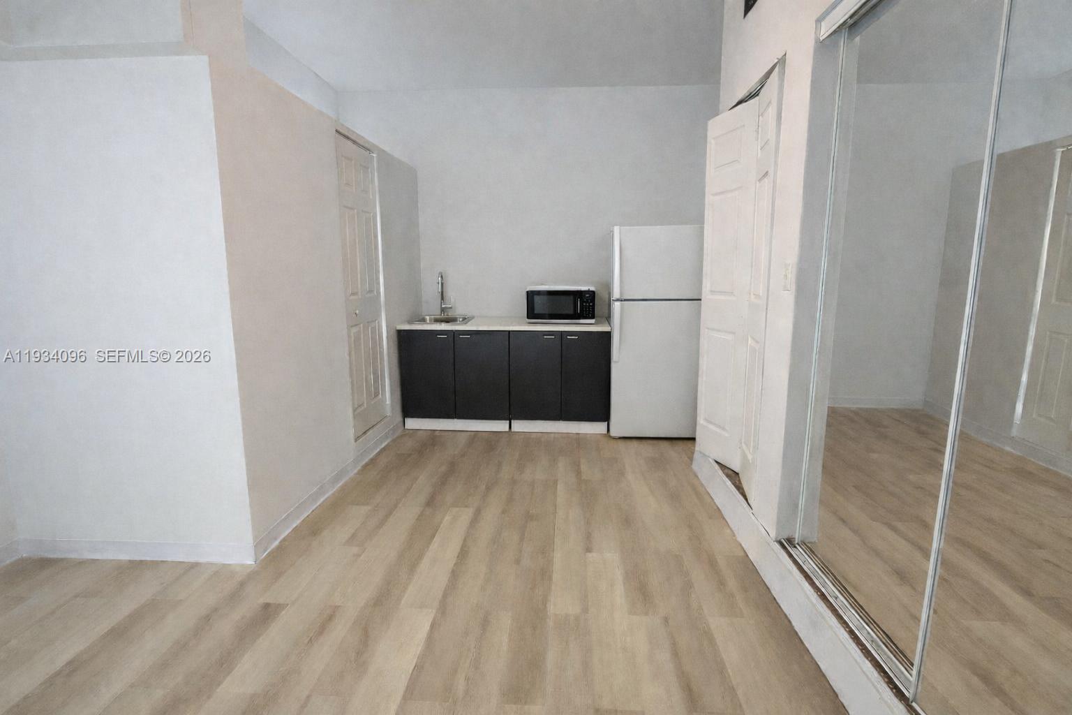 a view of a refrigerator in kitchen and wooden floor