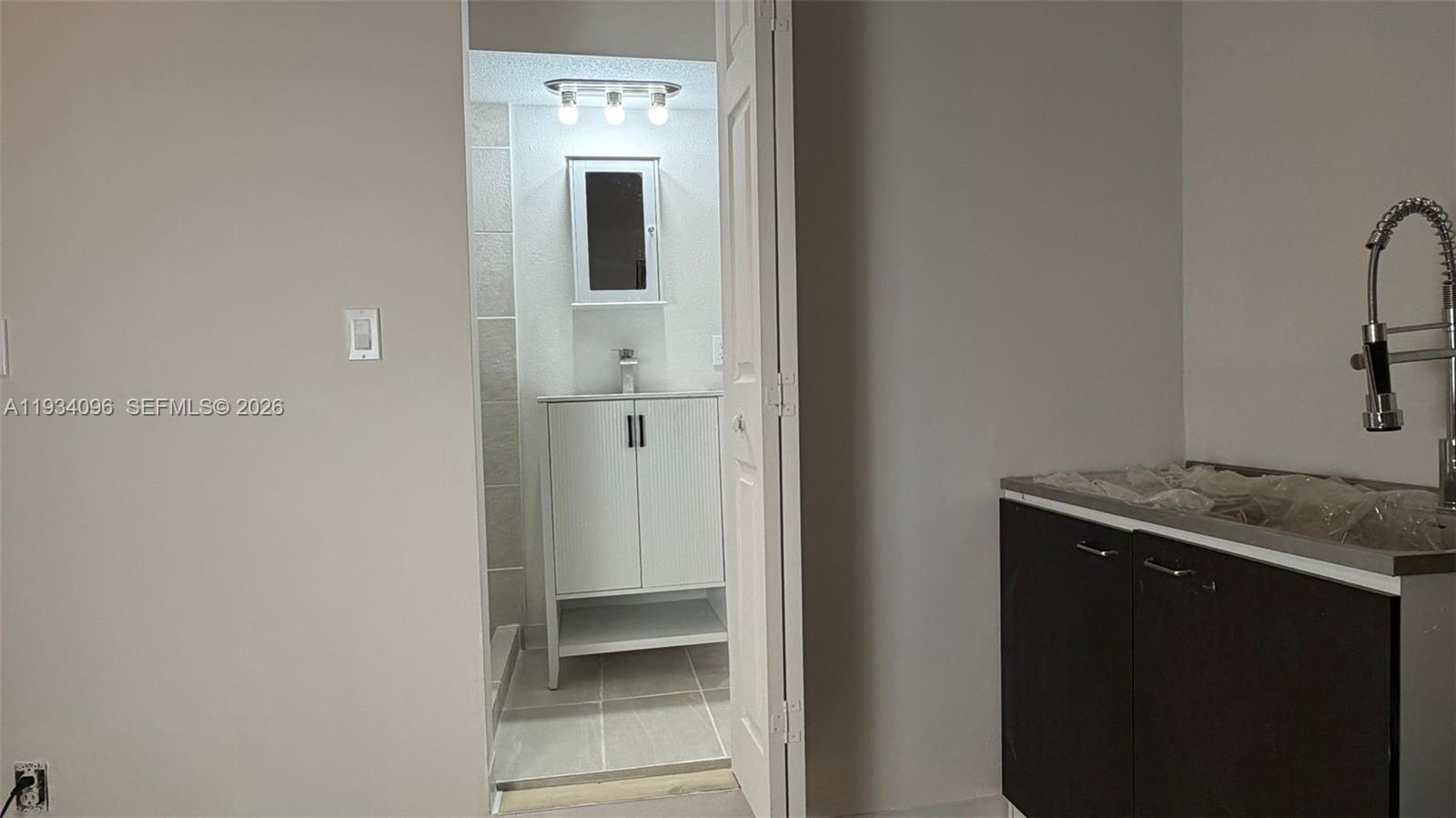 15730 Southwest 140th Street, Unit 15730 Miami, FL 33196 - Photo 4 of 10 a bathroom with a granite countertop sink and washing machine