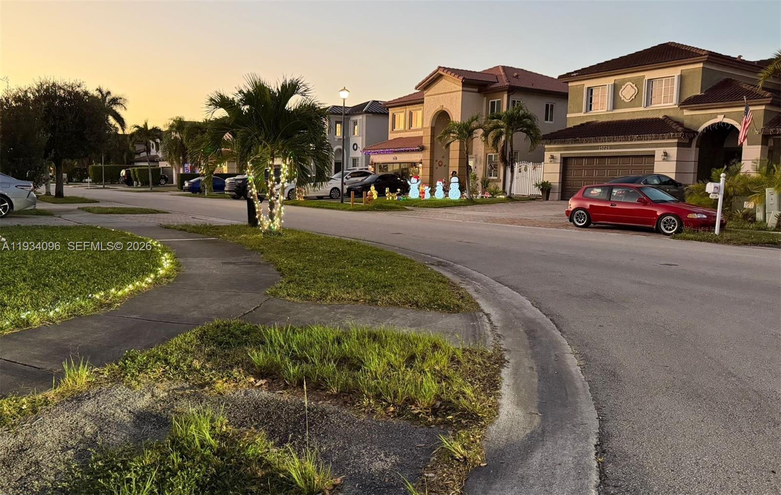 15730 Southwest 140th Street, Unit 15730 Miami, FL 33196 - Photo 9 of 10 a view of road with card parked on side and retail shops
