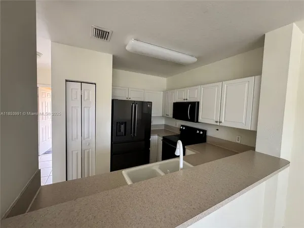 a kitchen with a refrigerator and a sink
