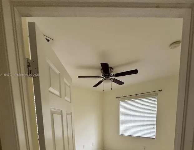 a view of a hallway with a ceiling fan