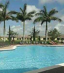 1485 Northeast 33rd Road, Unit 2121 Homestead, FL 33033 - Photo 4 of 19 a view of a swimming pool and trees in the background
