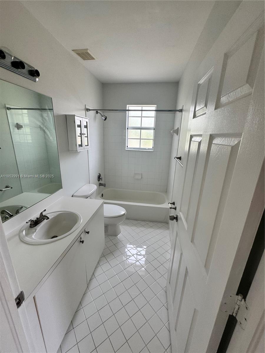 1485 Northeast 33rd Road, Unit 2121 Homestead, FL 33033 - Photo 8 of 19 a bathroom with a granite countertop sink a mirror a tub and shower