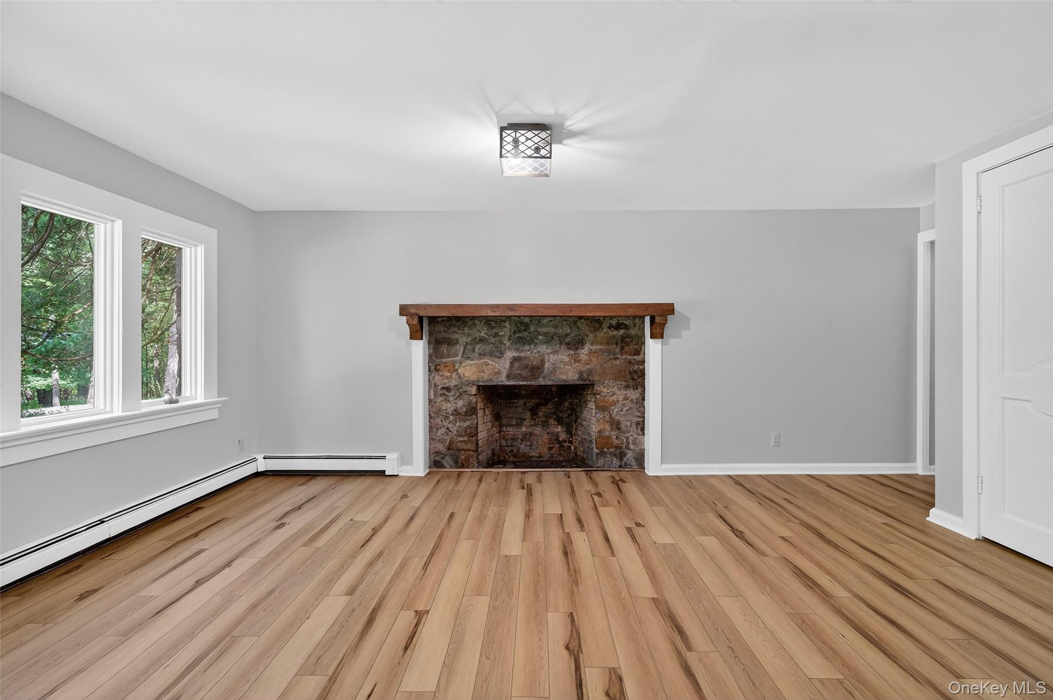 91 Sleepy Valley Road Warwick, NY 10990 - Photo 6 of 30 a view of empty room with wooden floor and fireplace