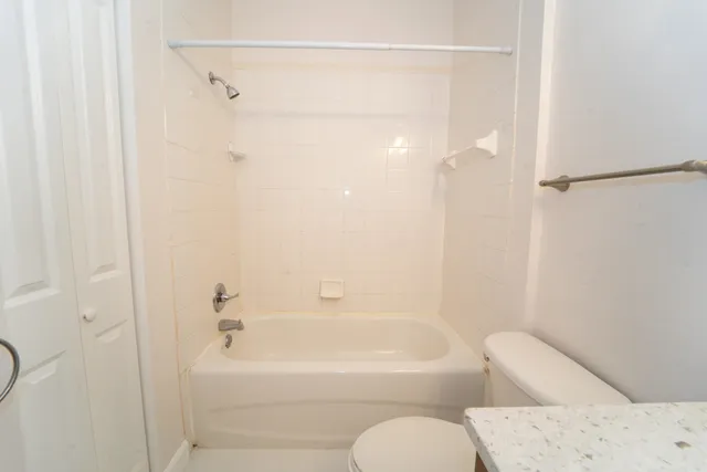 a bathroom with a bathtub shower and toilet