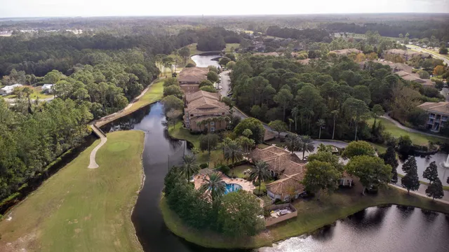 an aerial view of a house with a yard and lake view